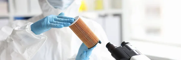 Naukowiec w kombinezonie ochronnym trzyma wkład filtracyjny w laboratorium — Zdjęcie stockowe