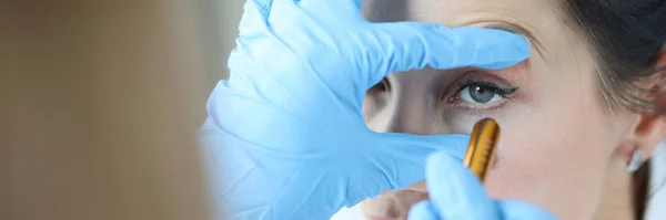 Dokter schijnt licht in het oog van de patiënt om pupil close-up te controleren — Stockfoto