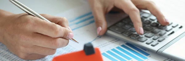 Mulher faz cálculos sobre calculadora para compra de casa a crédito — Fotografia de Stock