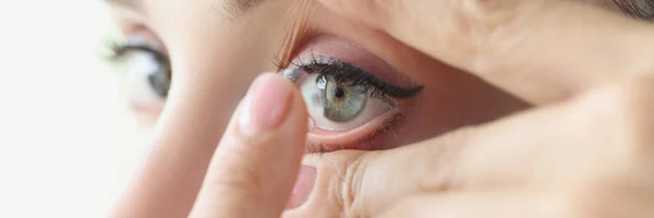 Woman puts on soft contact lenses closeup — Stock Photo, Image