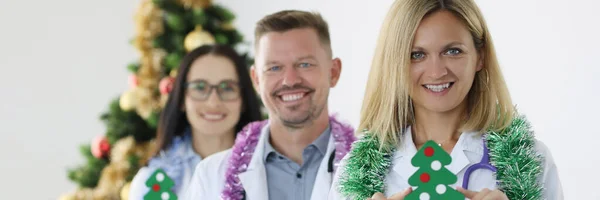 Team van lachende artsen houden kalender voor 2022 en kerstboom — Stockfoto