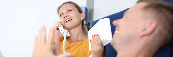 Mujer está hablando por teléfono mientras se acuesta con el hombre en la cama en la habitación de hotel — Foto de Stock