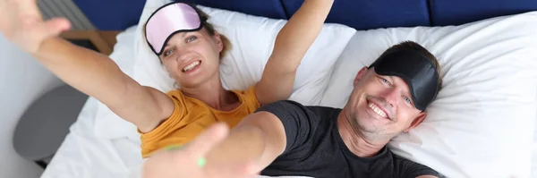 Счастливые молодой человек и женщина лежат на кровати — стоковое фото