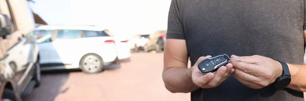 Чоловік тримає в руках кнопку пульта дистанційного керування від автомобіля крупним планом — стокове фото