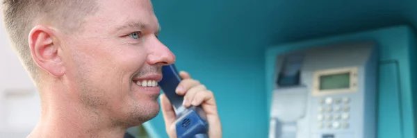 El joven está hablando por teléfono en la cabina telefónica. —  Fotos de Stock