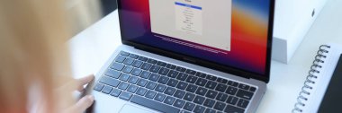 Apple MacBook 'un yeni dizüstü bilgisayarında dil seçen kadın hava kapanışı