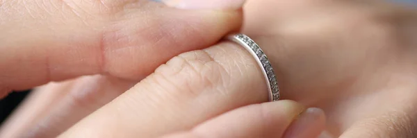 Woman hand putting silver ring on her finger closeup — Stock Photo, Image