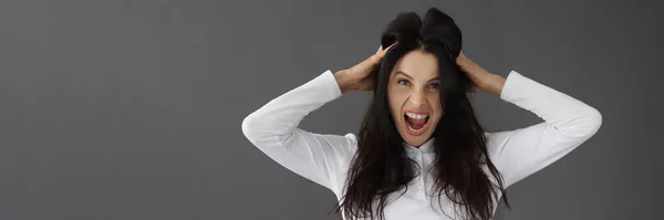Aggressivo giovane donna urlando e tenendo la testa con le mani ritratto — Foto Stock