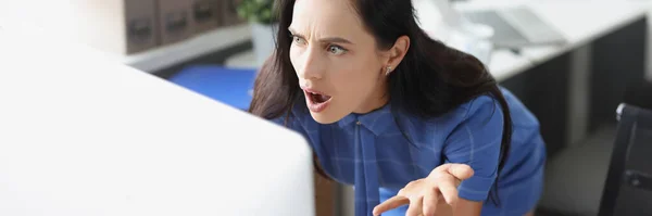 Überraschte Geschäftsfrau blickt im Büro auf Computerbildschirm — Stockfoto