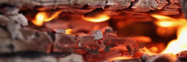 Fogo está queimando entre fundo closeup madeira — Fotografia de Stock