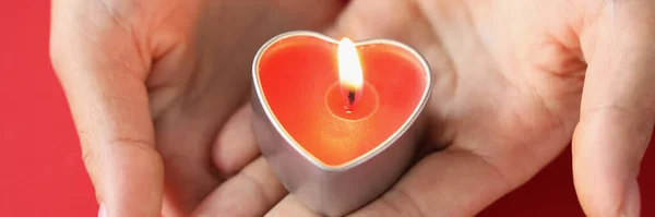 여성의 손에는 심장의 형태로 촛불을 태운다 — 스톡 사진