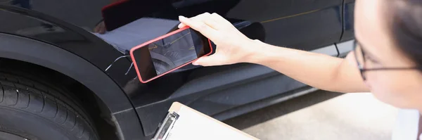 Versicherungsvertreterin fotografiert beschädigtes Auto mit Handy — Stockfoto