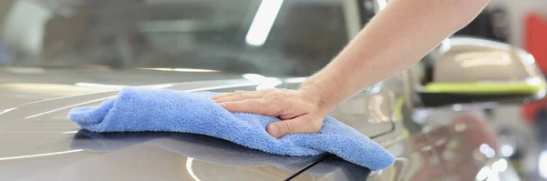 Man hand torka huva av bilen med microfiber tyg närbild — Stockfoto