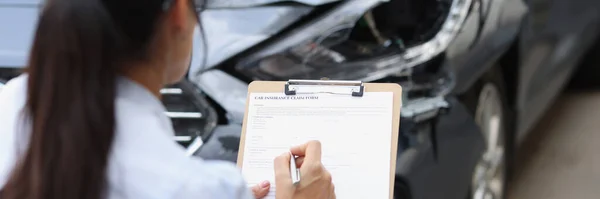 Versicherungsvertreterin füllt Antragsformular in der Nähe von Autowracks aus — Stockfoto