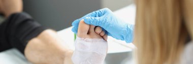 Dermatolojist travmatolog hasta harcı üzerinde tıbbi inceleme yapıyor.