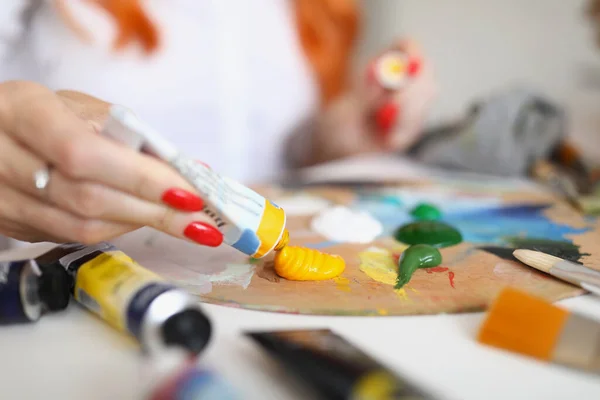 Женщина-художник сжимает краску для рисования крупным планом — стоковое фото