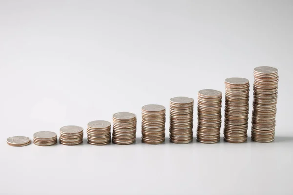 Montones de monedas de plata en orden ascendente sobre fondo gris claro —  Fotos de Stock