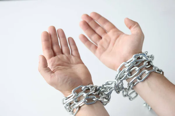 Las manos del hombre están atadas con cadena sobre fondo blanco —  Fotos de Stock