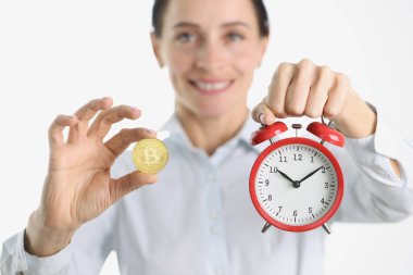 Altın Bitcoin ve çalar saat kadının elinde.