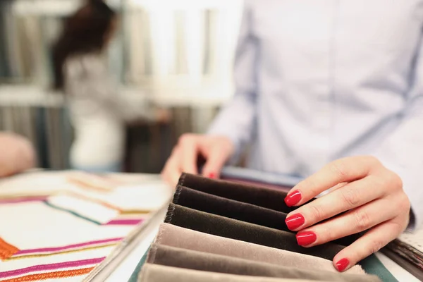 Жінка вибирає тканину в меблевому магазині крупним планом — стокове фото