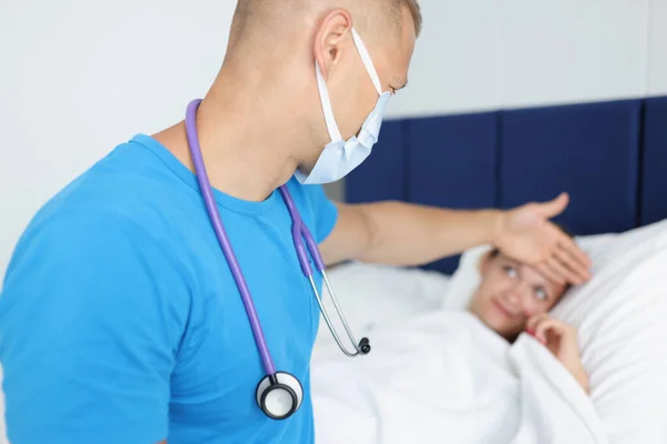 Medico con paziente covid-19 sdraiato a letto a casa — Foto Stock