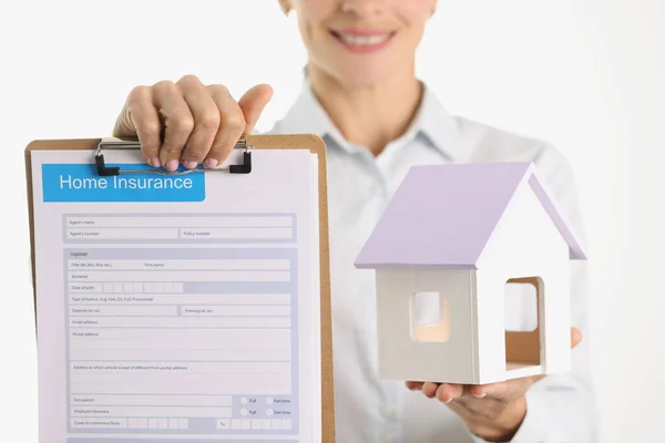 Uma mulher está segurando um documento de seguro doméstico em branco — Fotografia de Stock