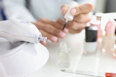 Manikürcü kadın, modern güzellik salonunda el değirmenleri kesiyor.