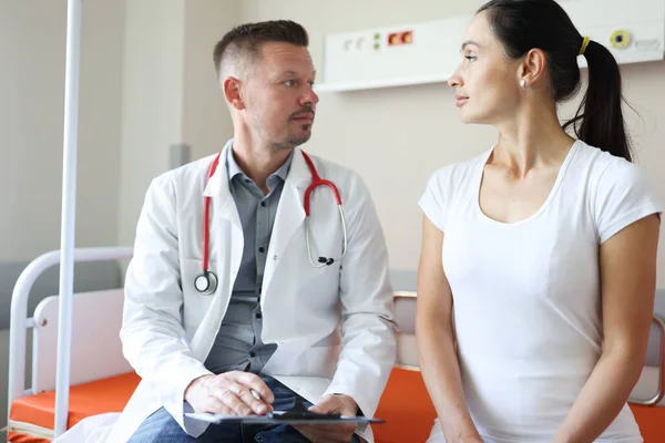 Médico masculino se comunica con paciente femenino en clínica —  Fotos de Stock