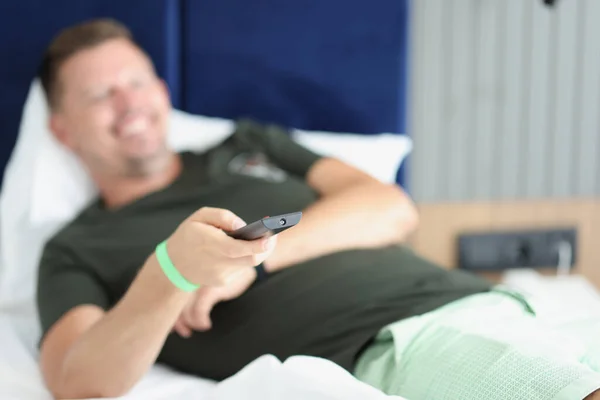 Homme couché souriant avec télécommande gros plan — Photo