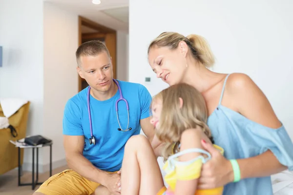 Läkare genomför läkarundersökning av barn med mor i hotellrum — Stockfoto