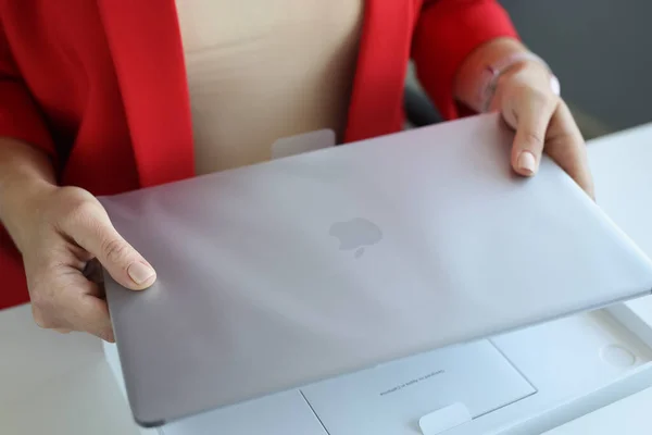 Vrouw houdt een Apple Macbook Pro laptop in pakket — Stockfoto