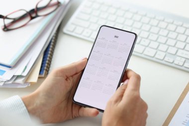 Takvimi ekranda olan akıllı telefon aygıtı, tatil planlaması ya da toplantı