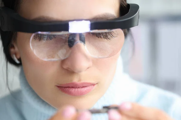 Female examine something wearing magnifying glasses with lighting — ストック写真