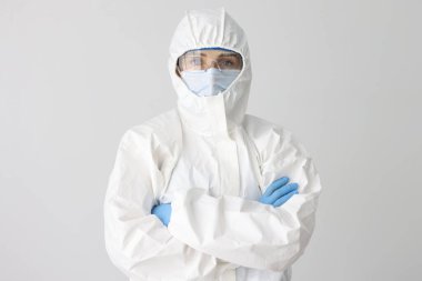 Koruyucu giysili, maskeli ve gözlüklü doktor.