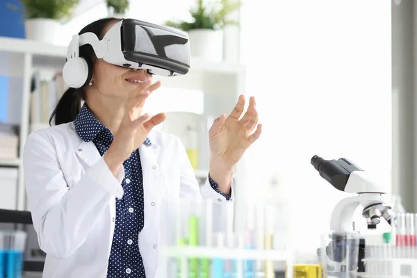 Доктор в виртуальных очках в лаборатории проводит эксперимент — стоковое фото