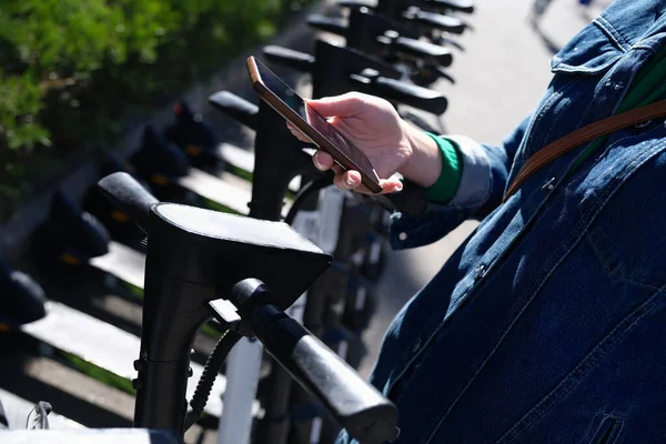 Frau mietet Roller per App auf ihrem Handy — Stockfoto