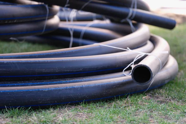 Twisted pipe for irrigation system lying on green lawn closeup — Foto de Stock