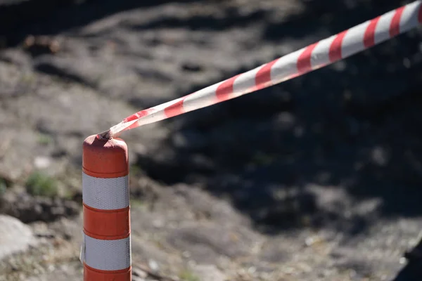 Red and white tape stretched in front of danger zone closeup — Photo
