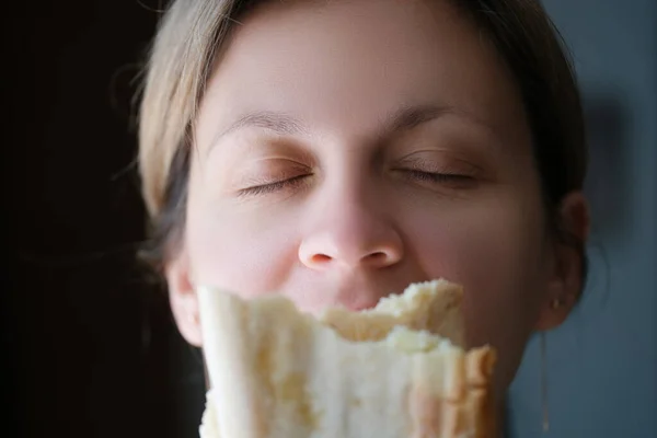 Donna annusare delizioso pezzo profumato di pane bianco — Foto Stock