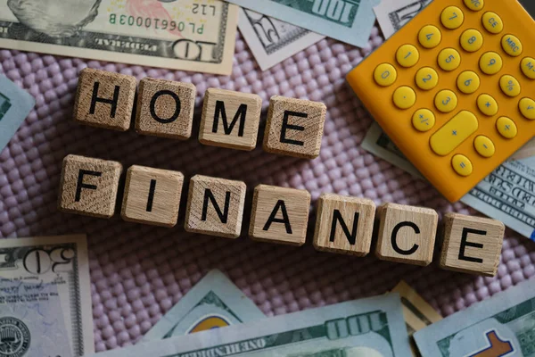 Dollaro bollette e calcolatrice sdraiato vicino a cubi di legno con parole home finance primo piano — Foto Stock