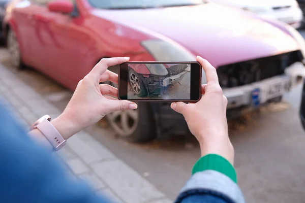 Woman holding smartphone and taking picture of car accident — Stock Photo, Image