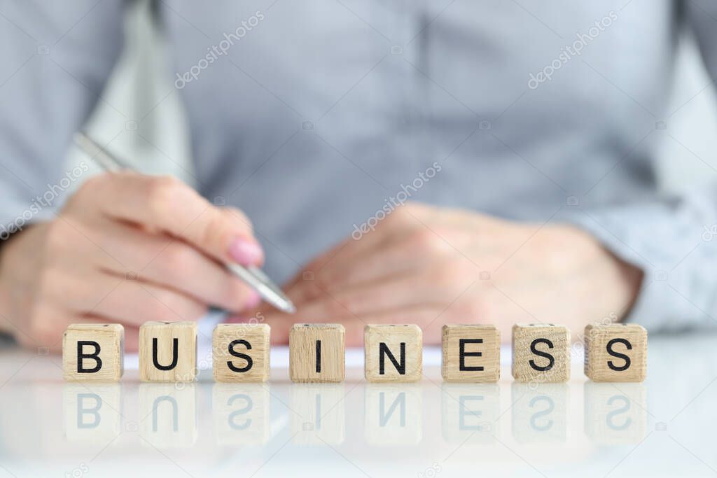 Business text and businessman hand with pen closeup