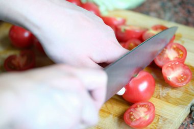 Aşçı tahtada domatesleri yakın plan kesiyor.