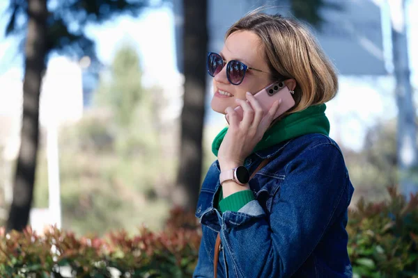 Χαμογελαστή γυναίκα που μιλάει στο τηλέφωνο στο δρόμο — Φωτογραφία Αρχείου