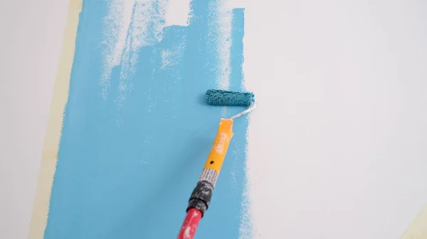 Hand painted wall. Painting walls with roller in blue — Stock Photo, Image