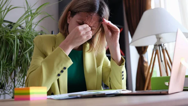 Tired business woman takes off glasses, feeling tired eyes from working at computer — Stok fotoğraf