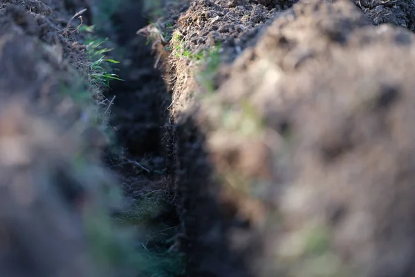 Trench in ground for electrical or internet cable at construction site — Fotografia de Stock
