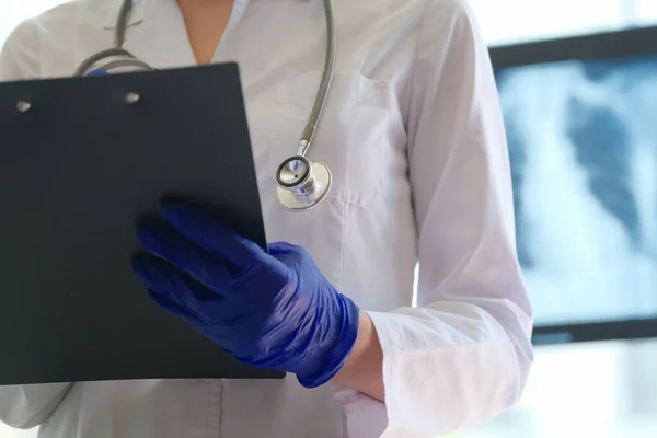 Lékař se schránkou vyplňující formulář pacienta — Stock fotografie