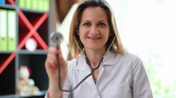 Joven doctora en el hospital sostiene estetoscopio —  Fotos de Stock