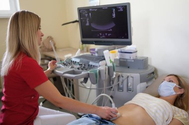 Jinekolog modern klinikte ultrason taraması yapıyor.